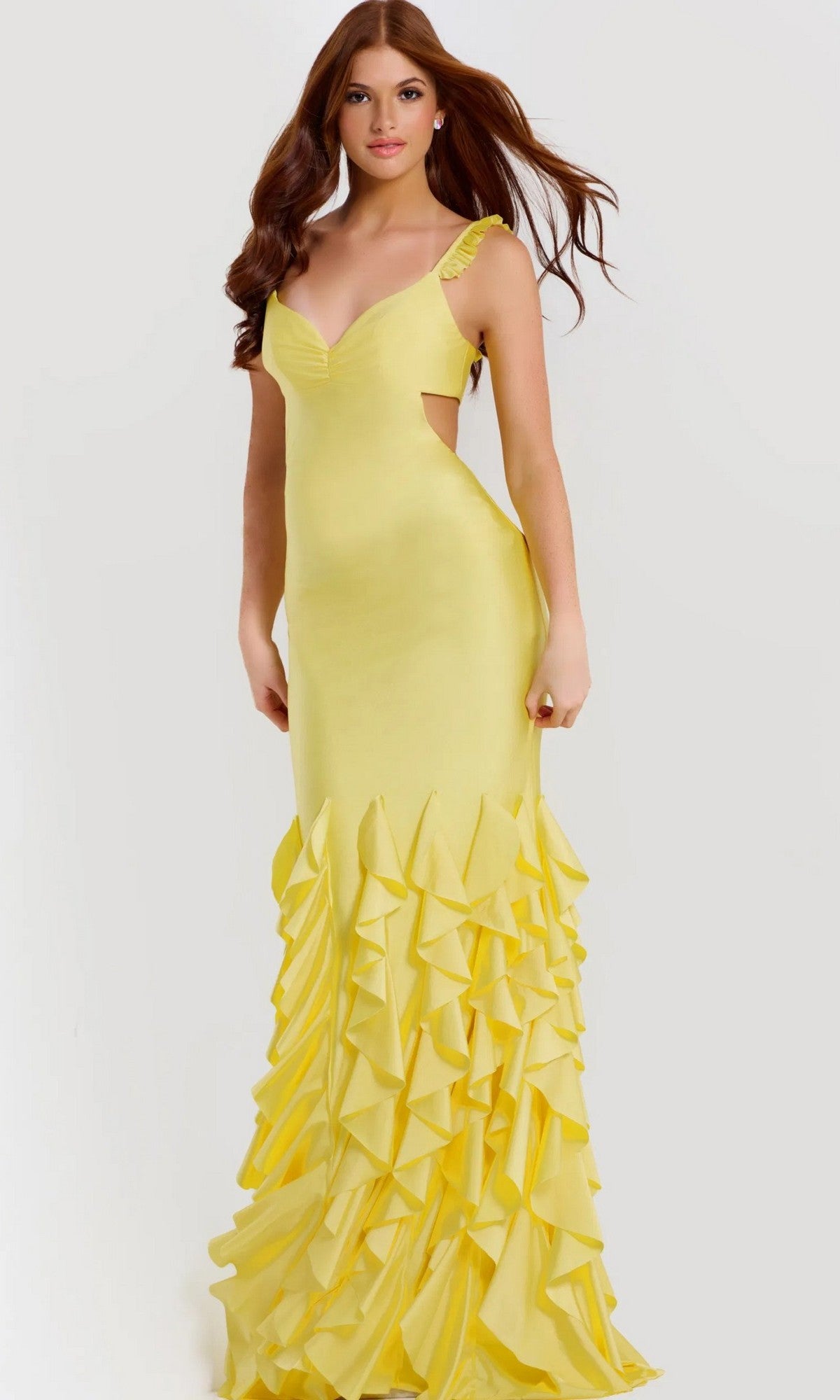 A woman stands against a plain light background wearing the yellow Long Prom Dress: Jovani 49897, featuring a sleeveless stretch-jersey design and a ruffle tiered skirt.